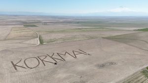 Aksaraylı çiftçiden 12 Mart’a özel mesaj: Tarlasına ‘Korkma’ yazıdırdı